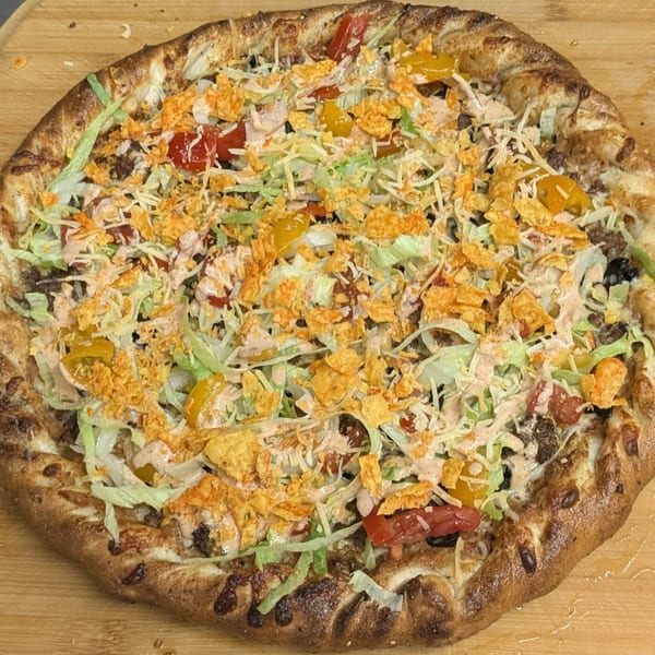 Heavy Metal Pizza's taco pizza, topped with ground beef, lettuce, cheese, tomatoes, and crushed chips.