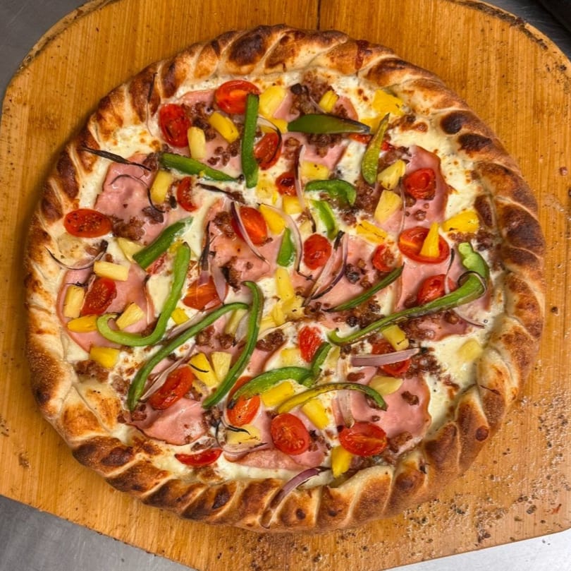 Heavy Metal Pizza's pizza with ham, pineapple, green peppers, cherry tomatoes, and onions.