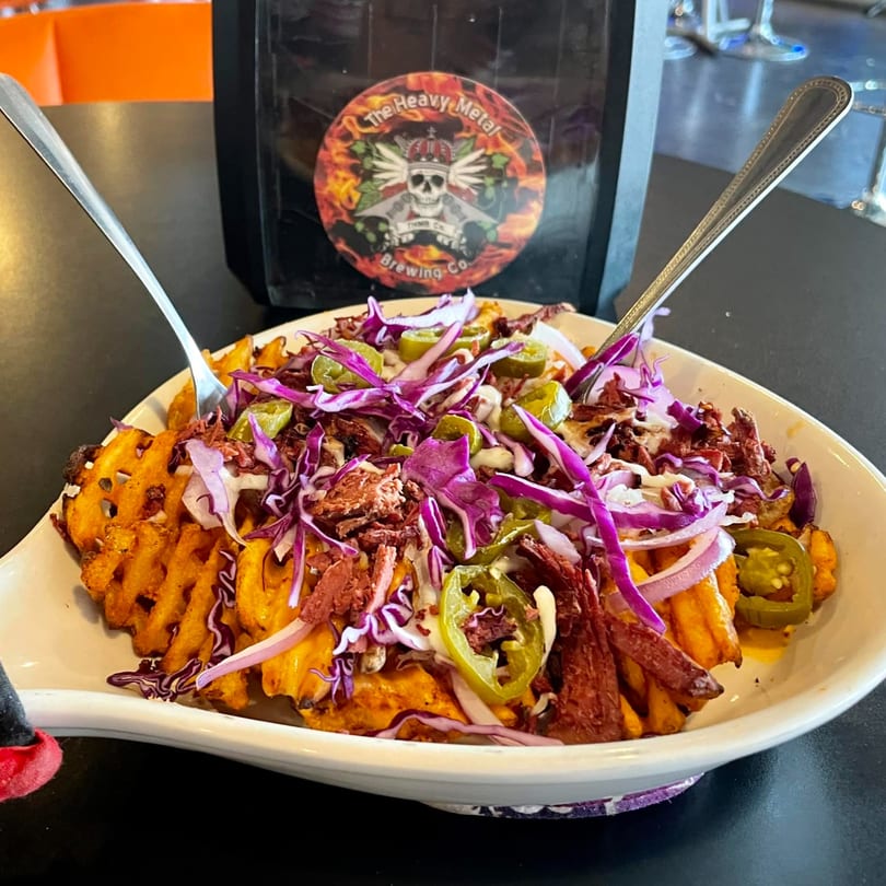 Heavy Metal Pizza's waffle fries loaded with corned beef, red cabbage, onions, jalapeños, and sauce.